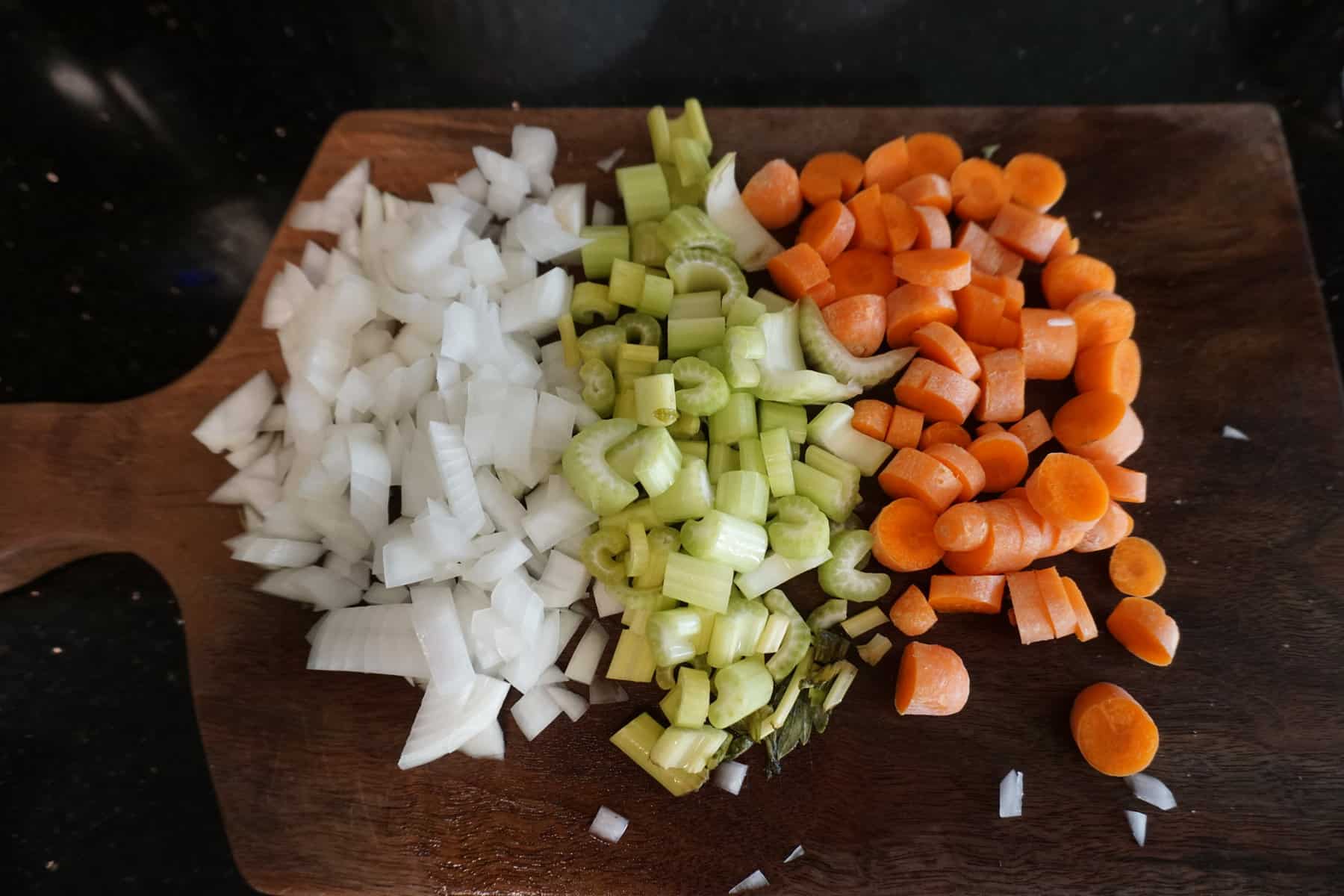 colorful chopped up vegetables on a wooden cutting board
