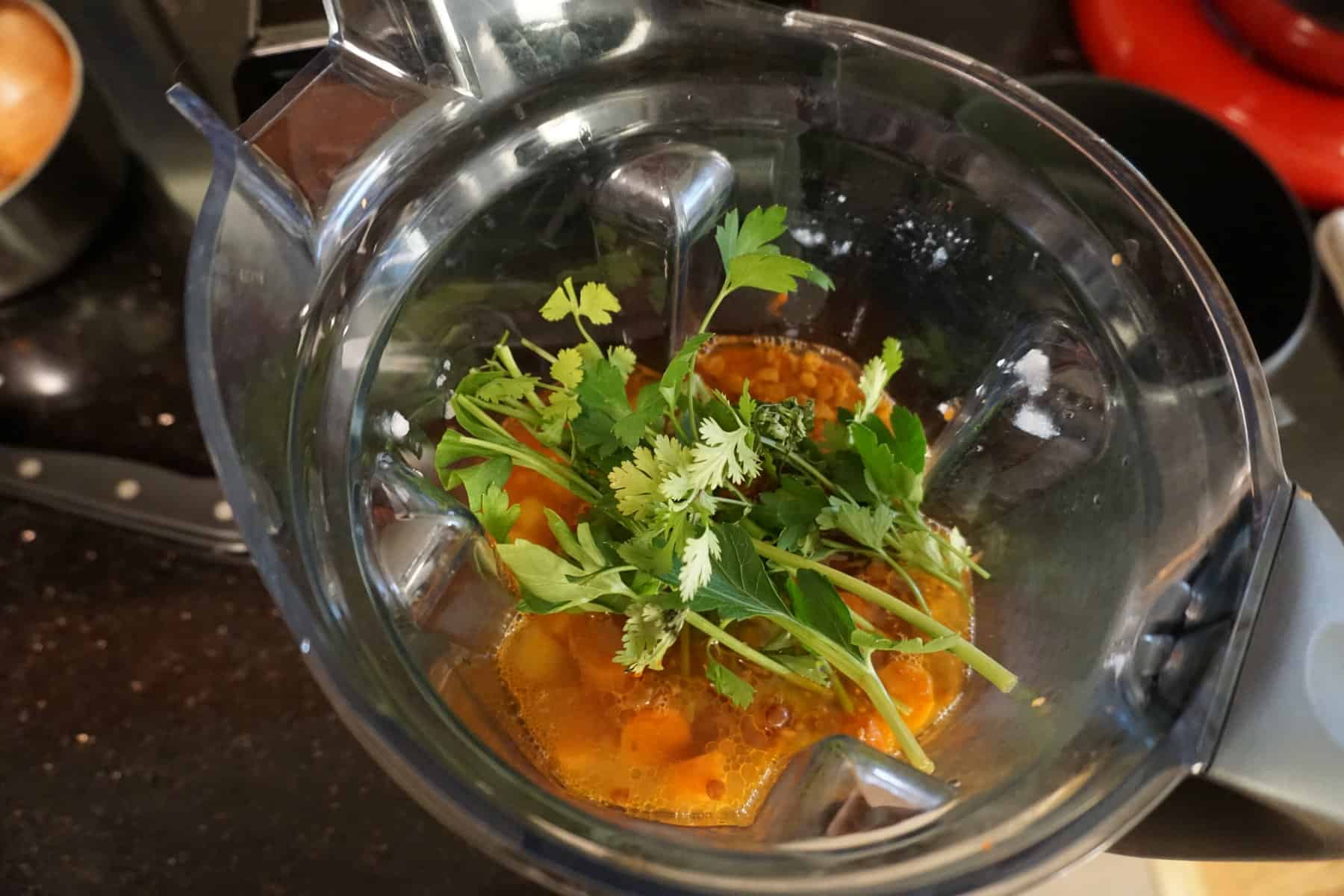 add herbs into a blender with water and cooked lentils to make blended tomato and lentil soup