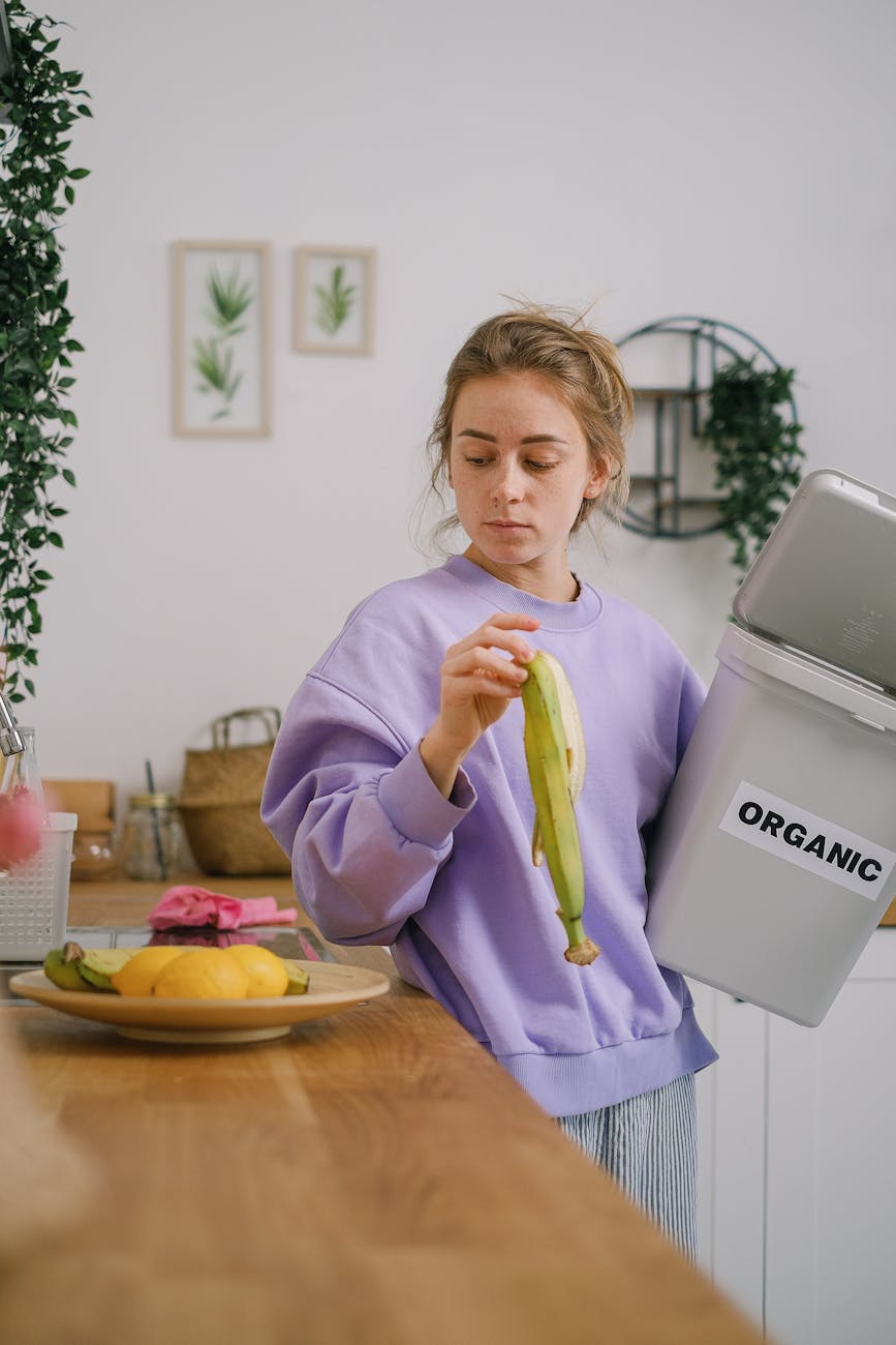 woman standing on a counter holding a banana peel