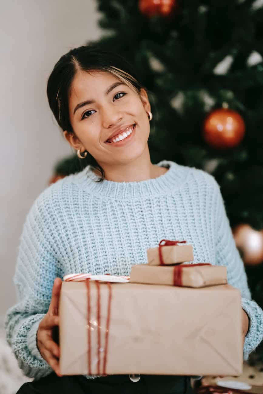 cheerful ethnic woman with gift boxes on christmas day
