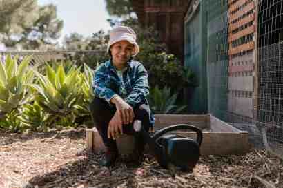 photograph of a girl sitting near a watering can