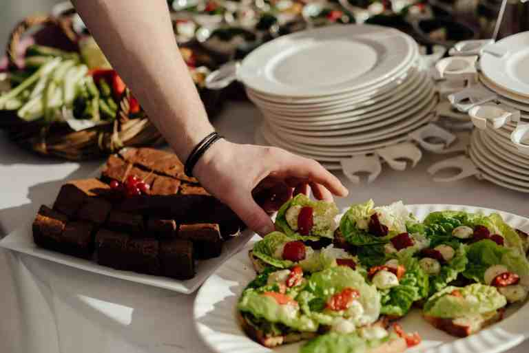 unrecognizable man taking delicious appetizer with lettuce