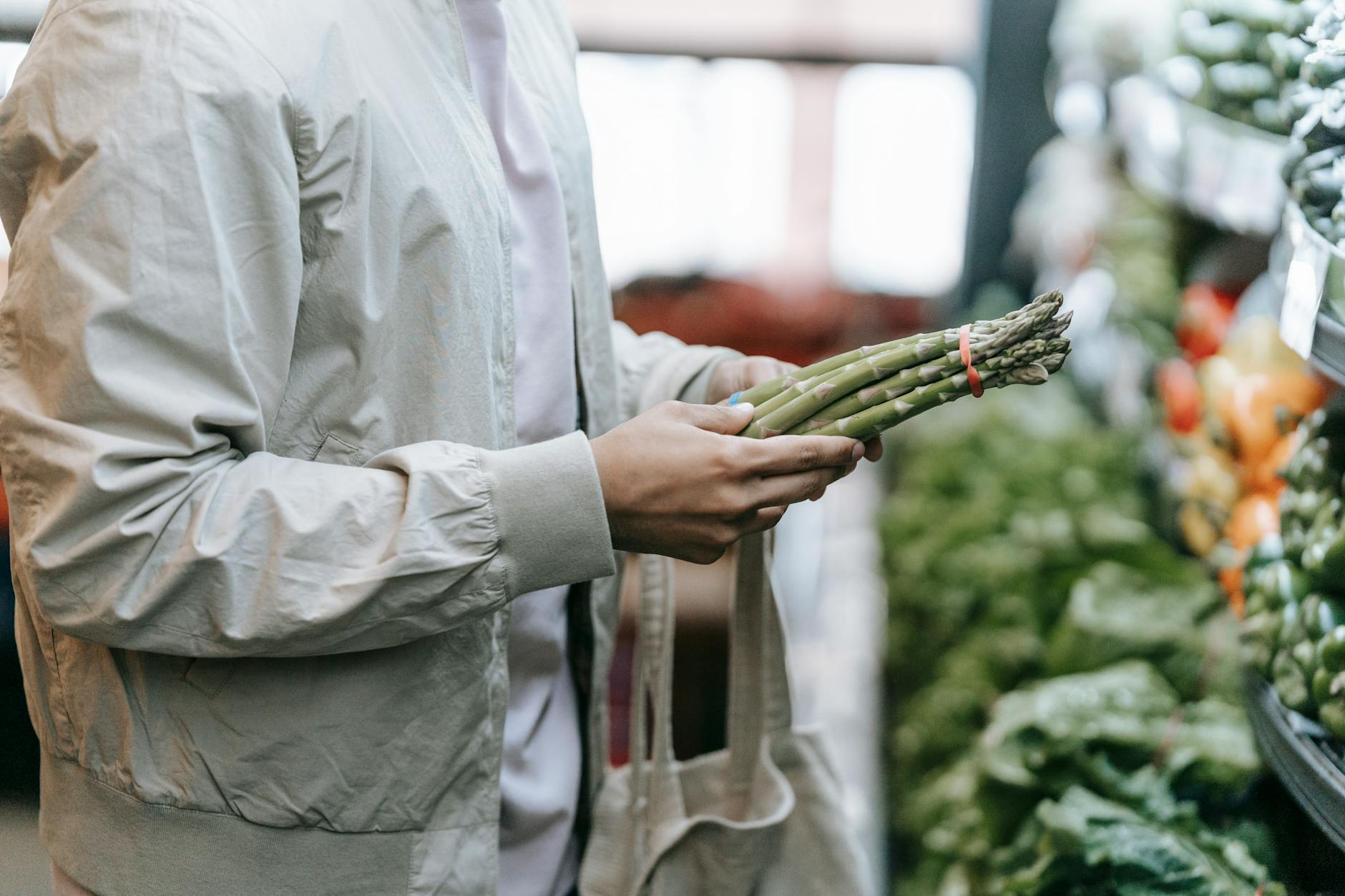 unrecognizable customer with asparagus in supermarket - avoiding greenwashing in food
