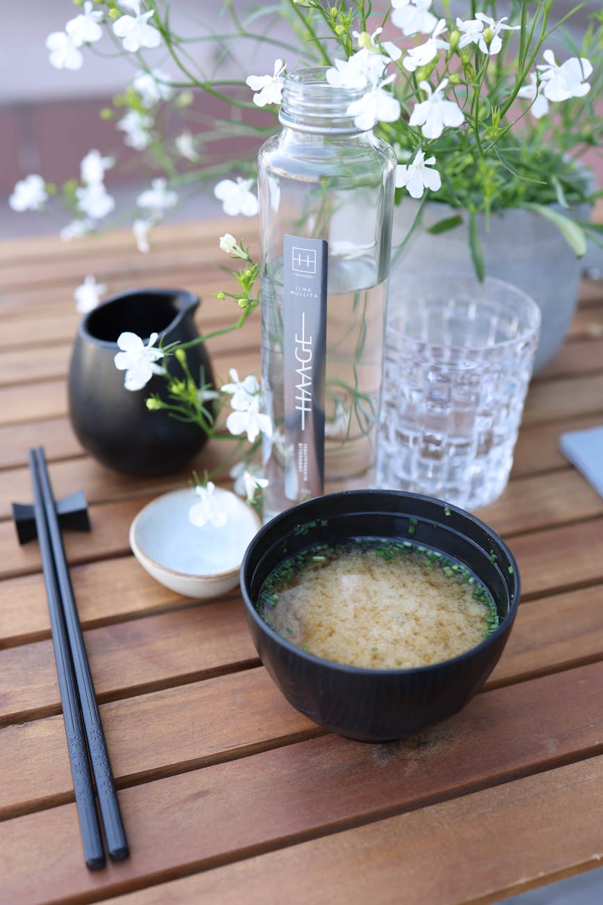 black bowl of miso soup and chopsticks