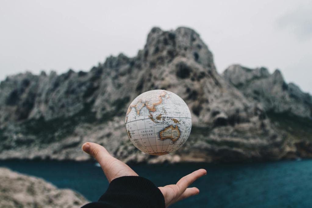 person tossing globe to celebrate earth day inspiration