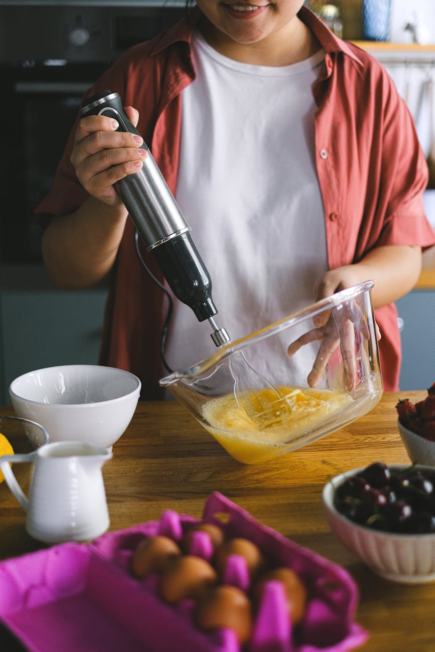 a person beating eggs with a hand mixer vs immersion blender