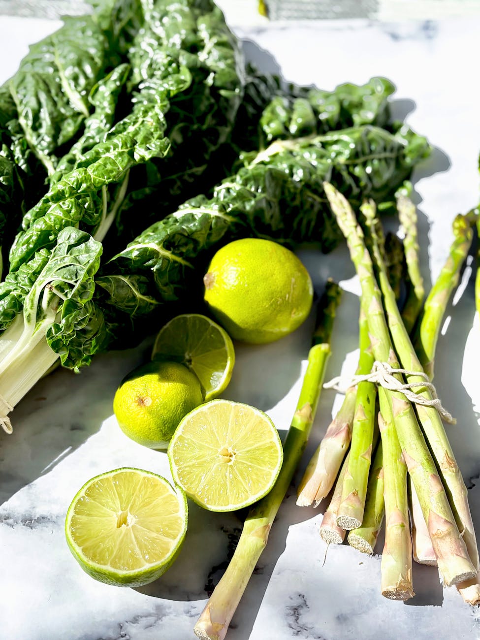 fresh green vegetables and limes on marble
