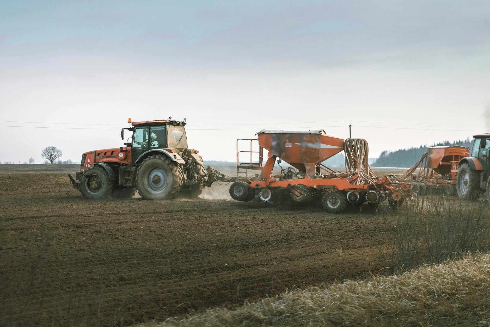 tractors with strip till sowing machinery working in field